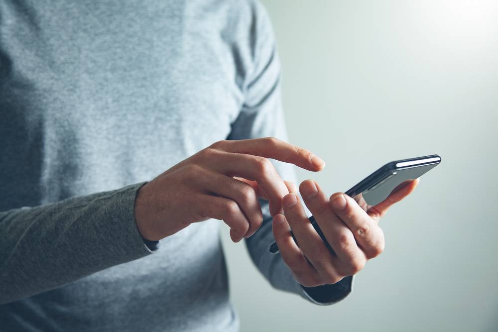 1 -celoveka-derzasaa-smartfon.jpg