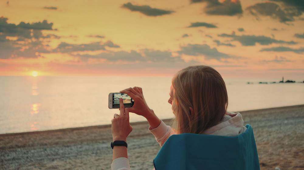 3 -vid-zensiny-fotografiruusei-na-nebe-vo-vrema-zahoda-solnca.jpg
